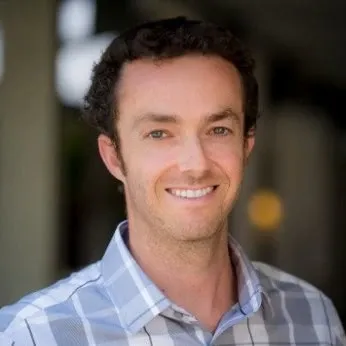 Portrait of Josh Shapiro, smiling, wearing a blue plaid shirt, outdoors