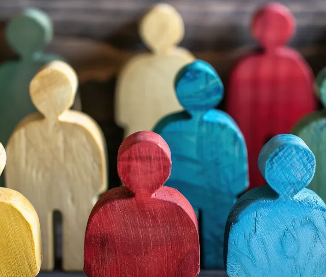 Close-up of painted wooden figures in red, blue, yellow and green standing together